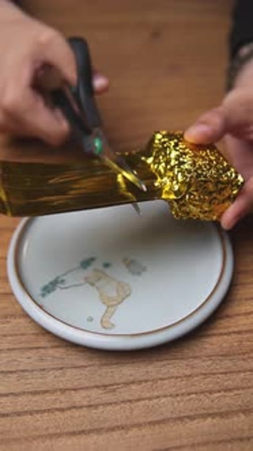 Engaging in the Creative Crafting Process Using Gold Foil Alongside a Pair of Scissors Media