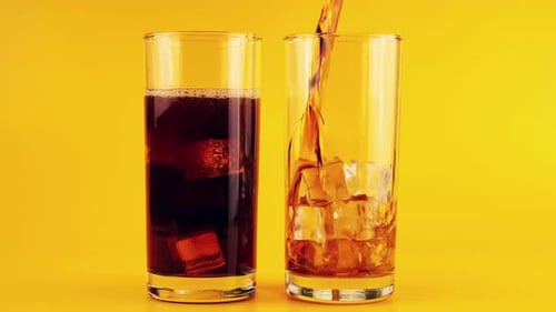 Dark Soda Being Poured into Glass with Ice