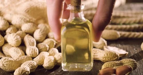Macro shot, peanuts and a drop of oil falling on them, as a symbol of a genuine peanut oil and goo