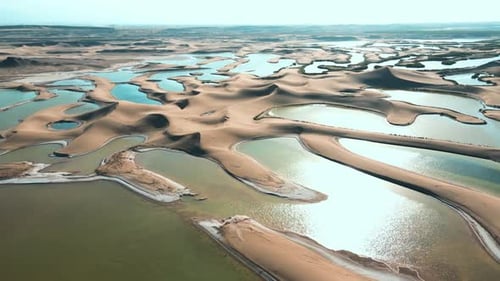 Aerial Shot of Oasis Amidst Desert Dunes