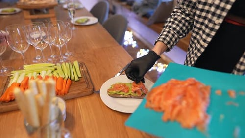 Frau macht Sandwiches mit gesalzenem Lachs und Avocado