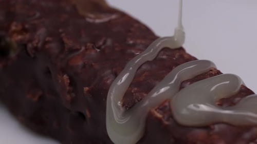 Slow-motion of condensed milk pouring over bar, highlighting rich creamy texture