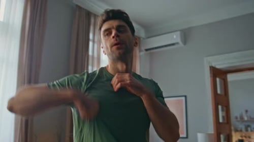 Man Exercising at Home in Green Shirt