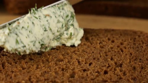 Spreading Cream Cheese on Rye Bread Slice