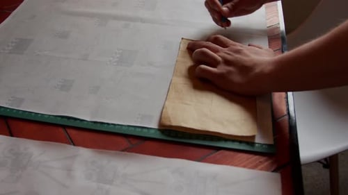 Ein Paar Hände markieren den Stoff mit einem Muster. Zeitlupe.