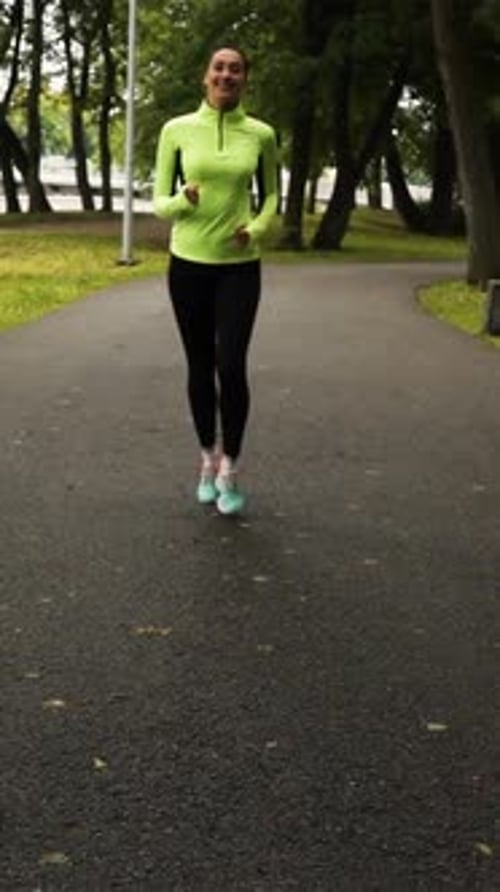 Vertical of Sport Woman Running in Park Exercising Outdoors