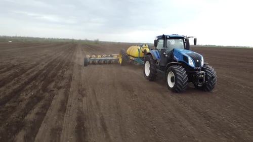 Blue tractor OA working on the field in Ukraine
