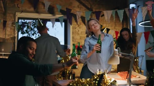 Colegas se divertindo em uma festa no escritório, alegre equipe de negócios multirracial dançando