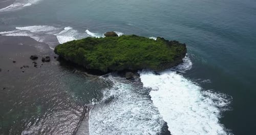 Aerial view of tropical beach with blue water and waves crashing coral rock