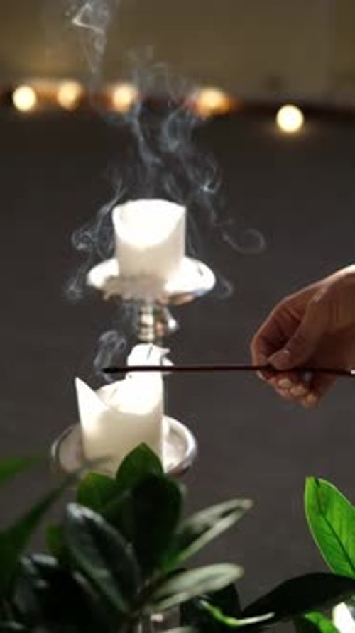 Hand Extinguishes Candle in Dark Room