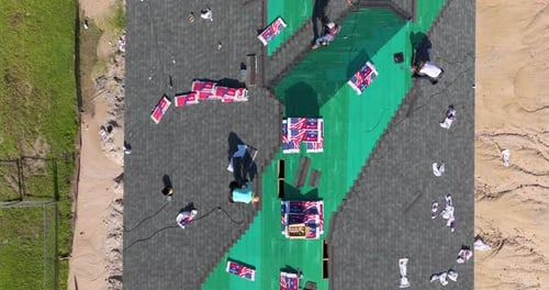Aerial View of Roofers Installing Shingles on Roof