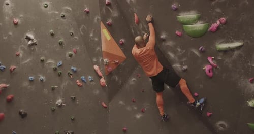 Athlete Male Rock Climber Exercising on Indoor Climbing wall