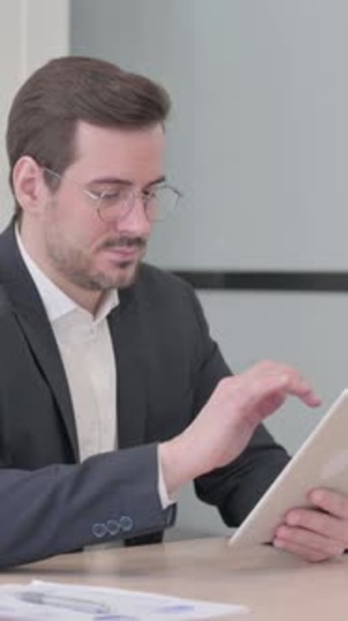 Man in Suit Uses Tablet at Desk