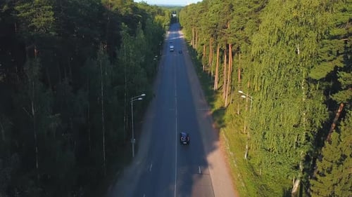 Top view of highway with cars in forest area on summer day