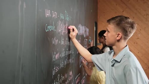 Seitenansicht eines Jungen, der mit verschiedenen Freunden Code an die Tafel schreibt. Erbauung