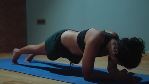 Woman practicing side plank exercise indoors