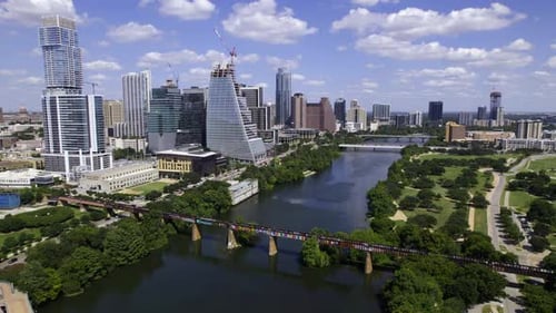 Aerial view of the river and downtown Austin skyscrapers, in sunny Texas, USA - tracking, drone shot