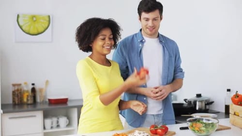 Happy couple preparing food together in a bright kitchen