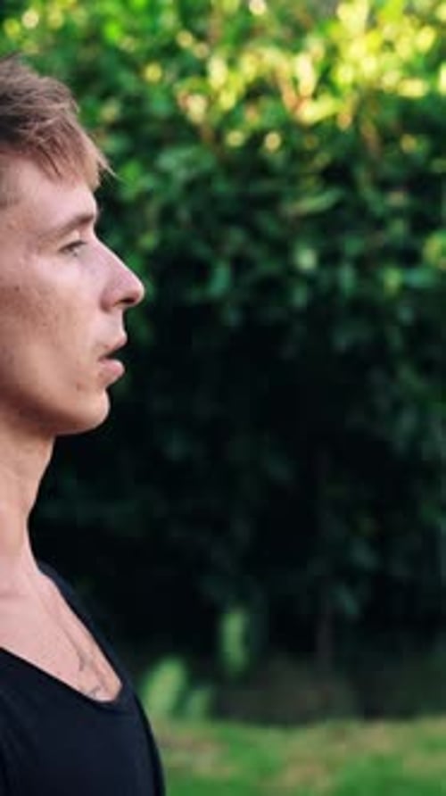 Yoga Breathing and Meditation of Young Man on Retreat Praying in Green Nature