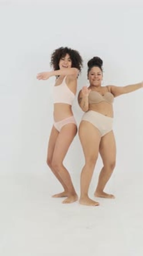 Two Women in Lingerie Dancing on White Backdrop