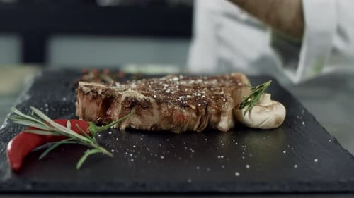 Chef Seasoning Delicious Steak in Restaurant Kitchen