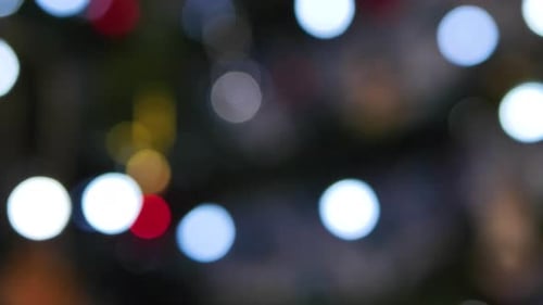 The Christmas artificial Christmas tree rotates with lights, Christmas lights. Blurred background. F