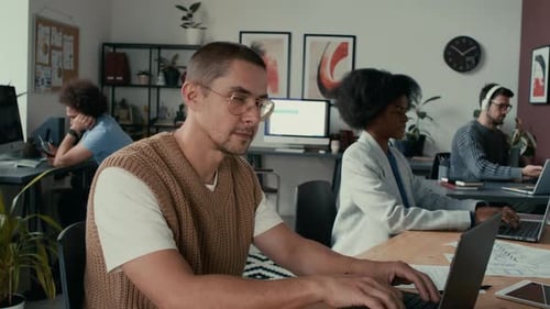Portrait of Man Using Laptop, Working on Project in Modern Open Space Office