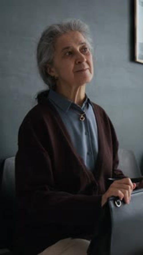 Elderly Woman Patiently Waiting in Bank Office Queue