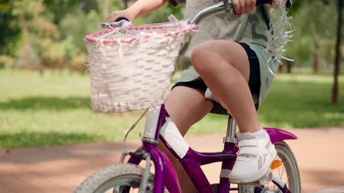 close-up of children's legs on pedals riding a bicycle in the park childhood active lifestyle