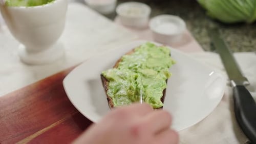 Spreading Avocado on Toast for Healthy Breakfast