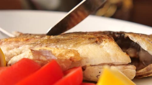 Preparing Delicious Cooked Fish with Knife and Fork