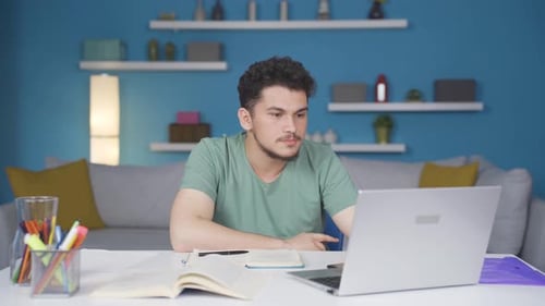 Man Works on Laptop at Desk in Home