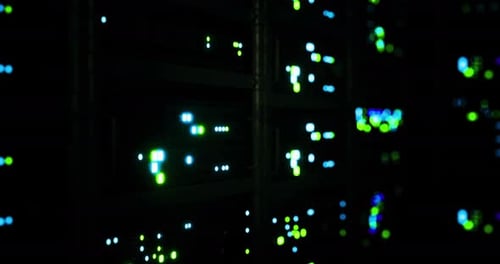Bright Lights Illuminate Server Racks in a Dark Data Center at Night