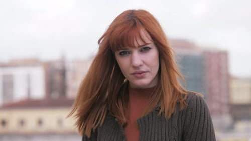 beautiful young woman on the terrace stares at camera with intense look