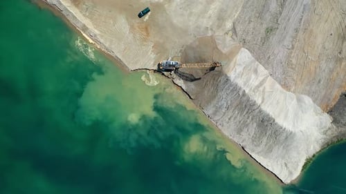 Aerial Drone View of a Big Yellow Excavator Moving Across the Sand