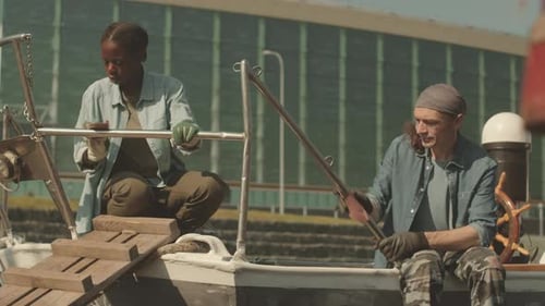 Diverse Couple of Sailors Cleaning Boat