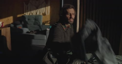 Man Packing Bag in Room With Sunlight