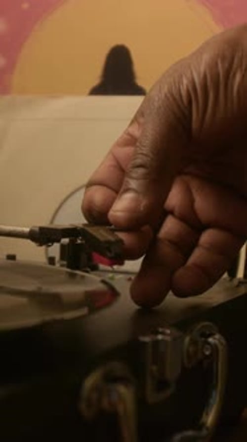 Vertical Close-up of Hand of Anonymous Black Man Lowering Tonearm on Turntable