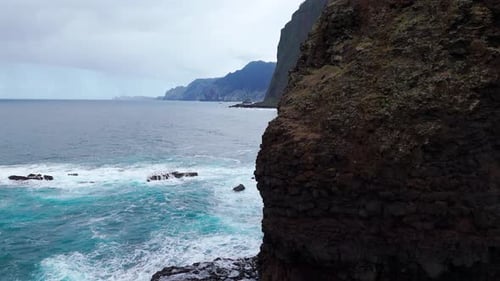 Calm Rocky Bay Sheltered By High Cliffs and Soothing Waves