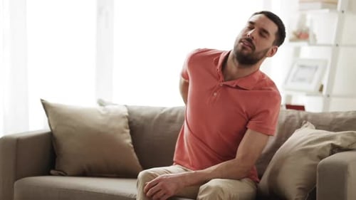 Man Sitting on Couch with Back Pain