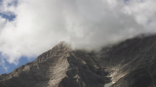 Conducir cerca de las altas cumbres de las Montañas Rocosas escondidas bajo las nubes