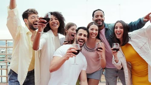 Smiling Friends Celebrate with Red Wine on Rooftop