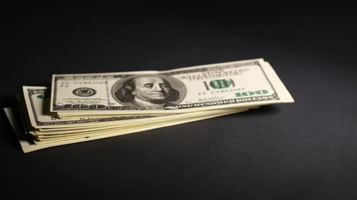 Close Up of Stack of Hundred Dollar Bills on Black Background