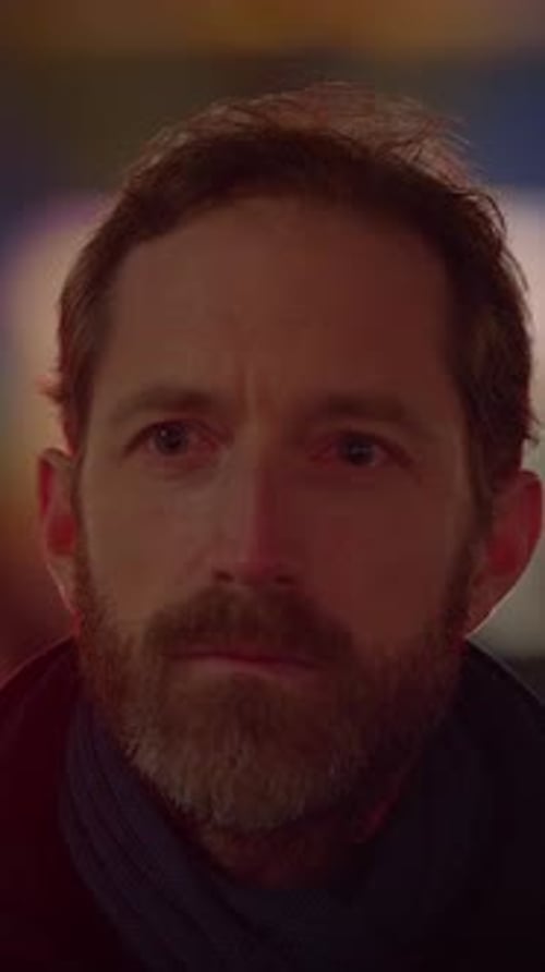 Bearded Man Puts On Glasses in City at Night