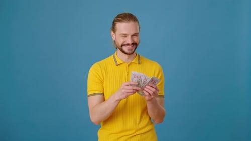Homem positivo contando a quantidade de contas de dinheiro no Blue Studio