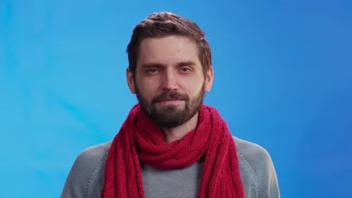 Man with Beard Removes Red Scarf in Studio