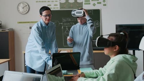 Teacher Teaching Boy to Use VR Glasses During IT Classes in School