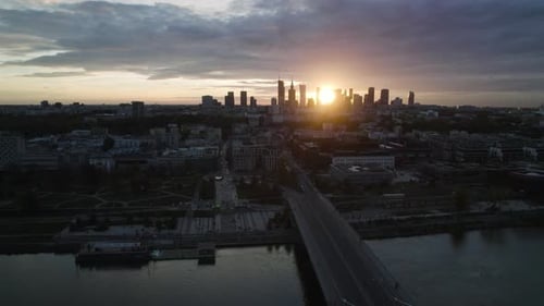 Aerial cityscape of Warsaw city by a bridge at Vistula shore at sunset
