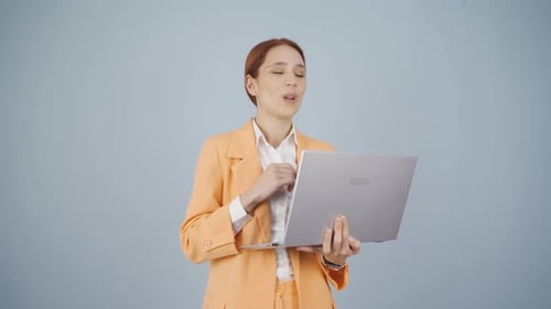 Smiling Woman Working on Laptop Wearing Pantsuit