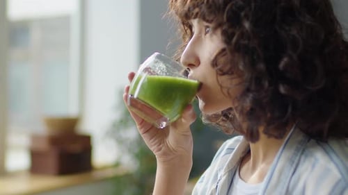 Girl Drinking Green Smoothie at Home